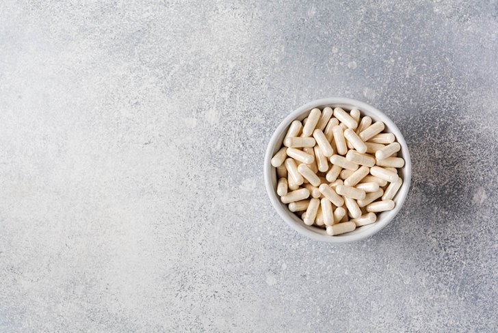 Collagen pills on gray concrete background. Healthy lifestyle concept. Copy space