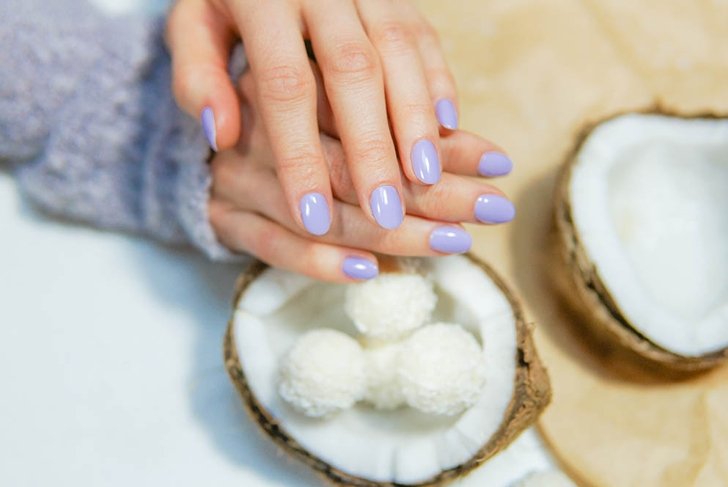 Stylish trendy female manicure. Beautiful young woman hands with purple gel polish